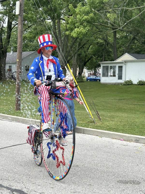 Man dressed as Uncle Sam on a high wheel bicycle