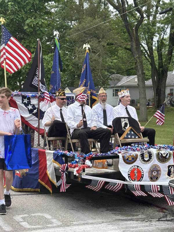Veterans riding a flag-covered parade float