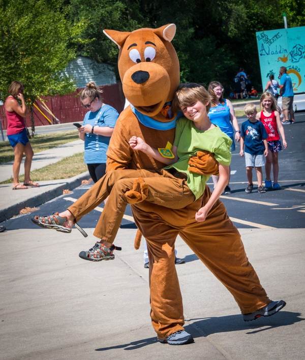Costumed mascot dancing with a child
